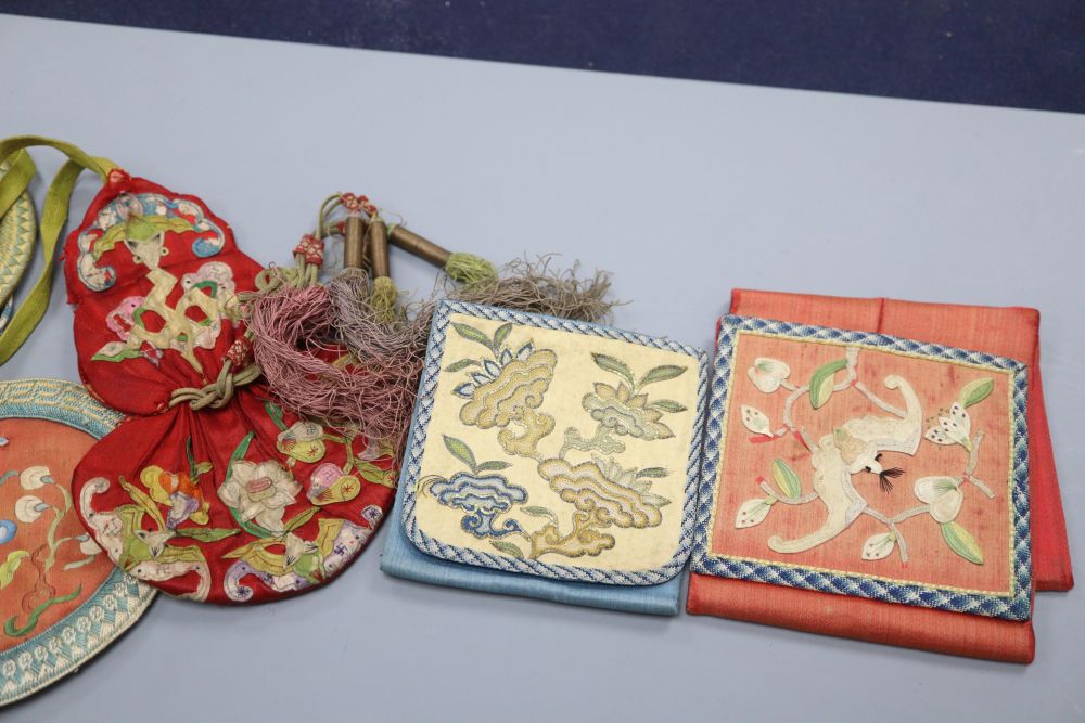 A collection of five Chinese embroidered purses, a red silk applique worked purse with silk tassels, finely embroidered petit point pur